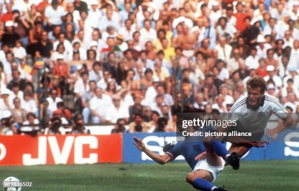 German defender Hans-Peter Briegel falls to the ground but still prevails against Italian midfielder Bruno Conti . Italy wins the final of the World...
