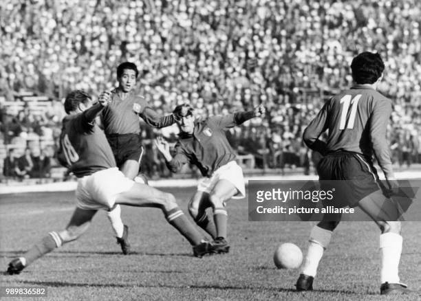 Italian defender David tries to reach the ball and lunges forward while Chilean forward Leonel Sanchez looks on during the 1962 World Cup group game...