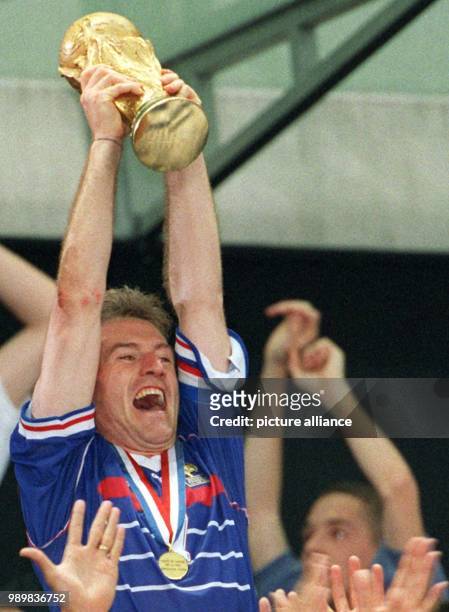 French team captain Didier Deschamps hoists the World Cup after France wins the 1998 World Cup final against defending champs Brazil at the Stade de...