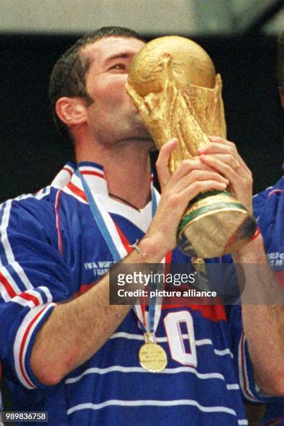 French midfielder and two time scorer in the final Zinedine Zidane kisses the World Cup after France wins the 1998 World Cup final against defending...