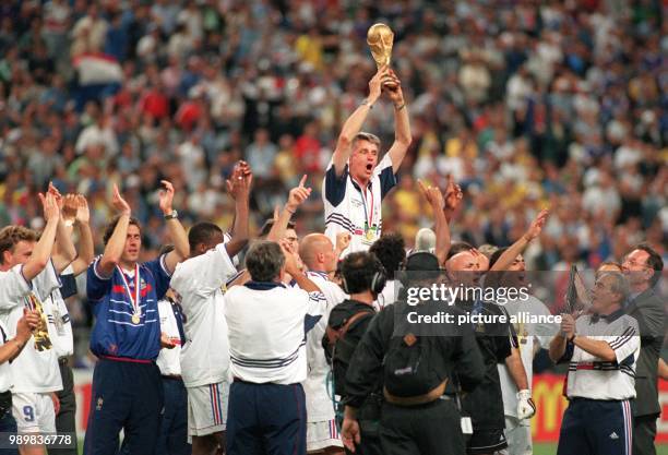 French players jubilate with the World Cup and their upheaved coach Aime Jacquet after France wins the 1998 World Cup final against defending champs...