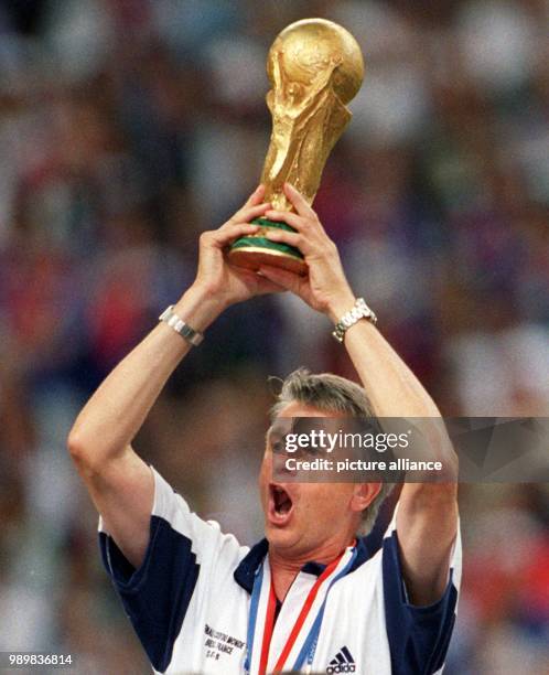 French national team coach Aime Jacquet jubilantly hoists the FIFA World Cup after the 1998 World Cup final France against Brazil at the Stade de...