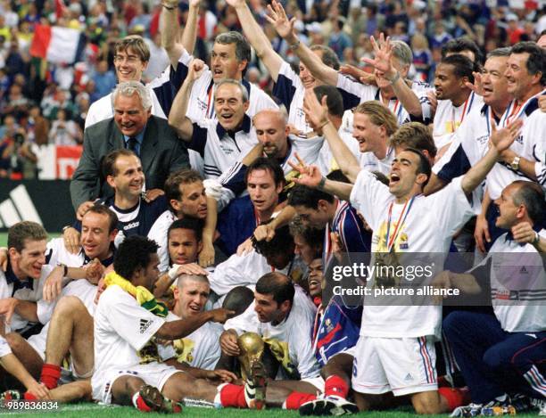 The French national soccer team groups together for a team picture and cheers as they celebrate together with trainers, coaches and assistants the...