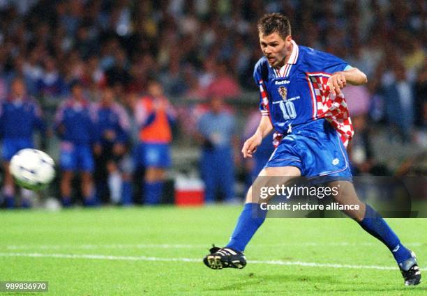 Croatian midfielder and team captain Zvonimir Boban stands clear of any opponent and kicks the ball towards the German goal during the 1998 World Cup...