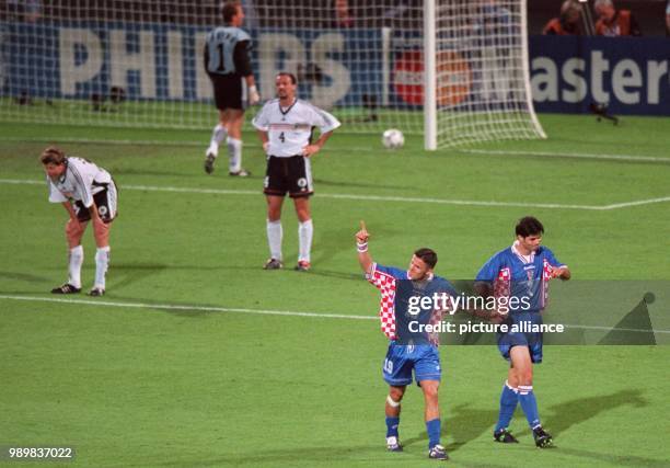 Croatian forward Goran Vlaovic gestures and cheers with his teammate Aljosa Asanovic , while German goalkeeper Andreas Koepke collects the ball from...