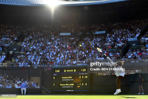 Player Serena Williams serves against Netherlands' Arantxa Rus during their women's singles first round match on the first day of the 2018 Wimbledon...