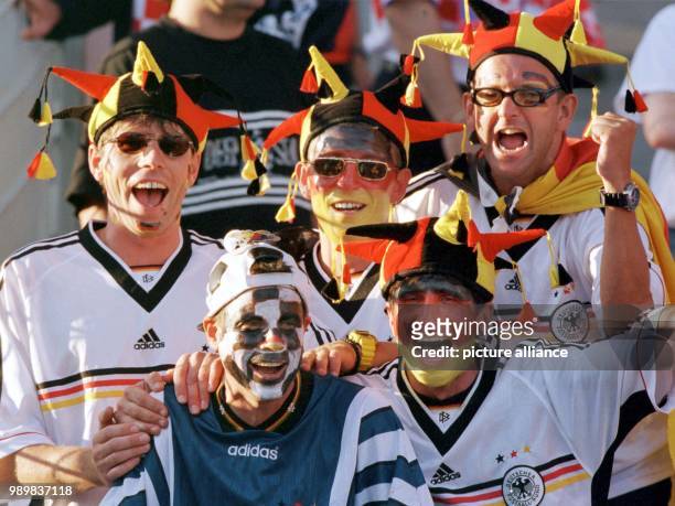 Good humoured German fans, with fool's caps and painted faces in the German national colours await tzhe start of the 1998 World Cup quarter final...