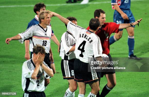 German forward Juergen Klinsmann , midfielder Lothar Matthaeus and defender Juergen Kohler argue with Norwegian referee Rune Pedersen about his...