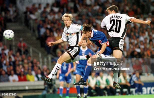 Croatian defender Dario Simic heads the ball in between the two German forwards Oliver Bierhoff and Juergen Klinsmann during the 1998 World Cup...