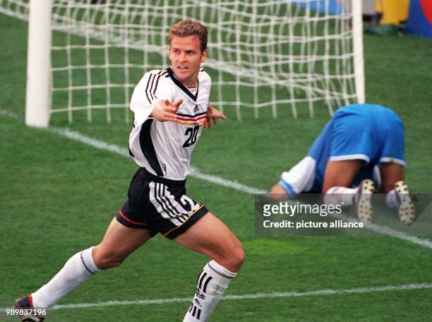 German forward Oliver Bierhoff cheers after scoring the final 2-1 goal, while Mexican goalkeeper Jorge Campos kneels defeated and devastated on the...