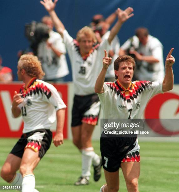 German players Rudi Voeller , Andreas Moeller and Juergen Klinsmann throw their arms in the air, cheer and jubilate after scoring a goal during the...
