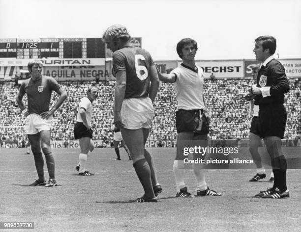 German forward Gerd Mueller backslaps English defender Bobby Moore in comfort after Moore was cautioned by the Argentine referee Angel Norberto...