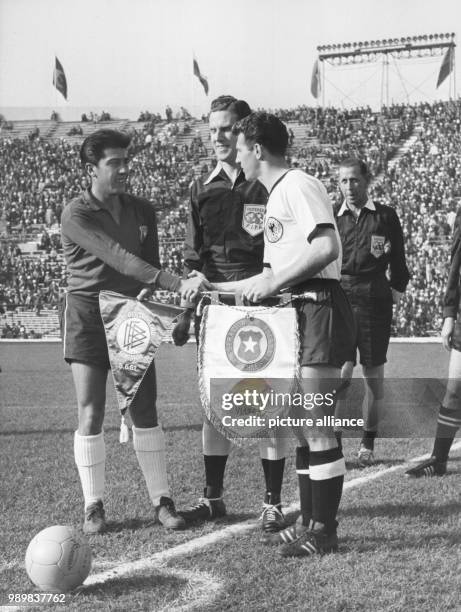 German team captain Hans Schaefer exchanges pennants with the Chilean captain, while next to them stands Scotish referee Davidson, prior to the start...