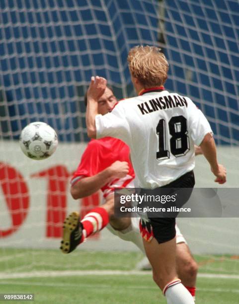 German forward Juergen Klinsmann tries to direct the ball past the Bulgarian midfielder Jordan Letschkov during the 1994 World Cup quarter final...