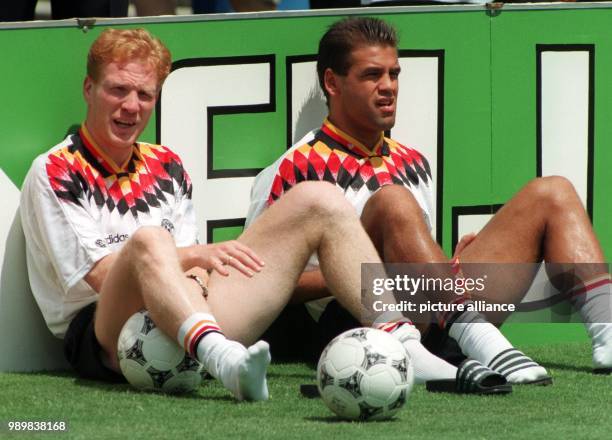 German midfielder Matthias Sammer and forward Ulf Kirsten sit behind the sideline of the pitch and watch the 1994 World Cup quarter final Germany...