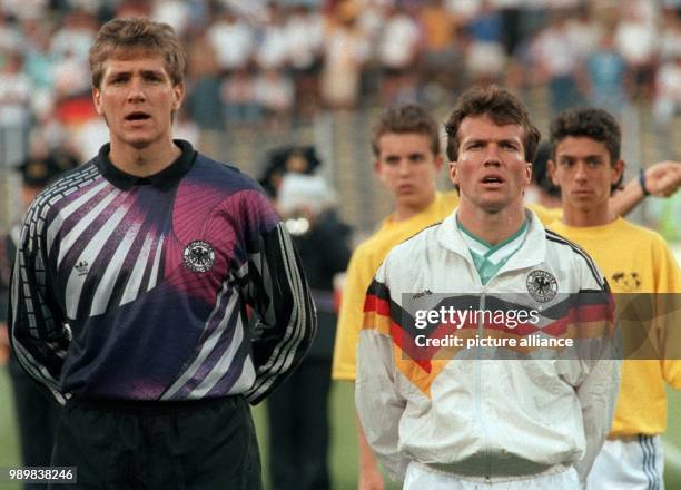 German Team captain and midfielder Lothar Matthaeus and goalkeeper Bodo Illgner stand alongside each other as they sing along during the presentation...