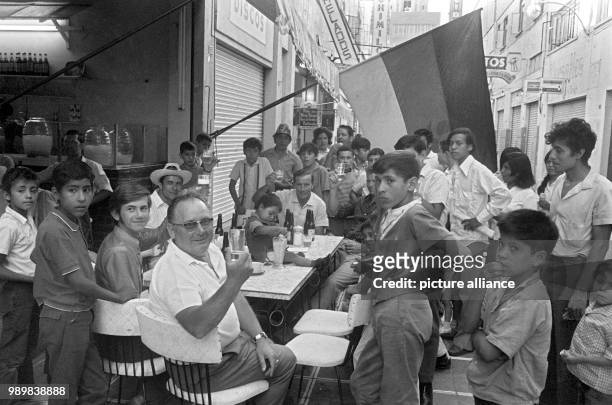 After the German team beat England 3:2 during the 1970 FIFA World Cup in Mexico, German fans are celebrating in a street cafe in Leon, surrounded by...