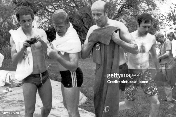 German national football players Hannes Loehr , Helmut Haller , Franz Beckenbauer and team coach Helmut Schoen are on the way to the swimming pool of...