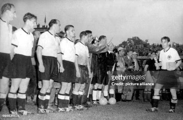 After beating Hungary 3:2 in the 1954 FIFA Word Cup final at Bern's Wankdorf stadium on July 4th, German team captain Fritz Walter is proudly holding...