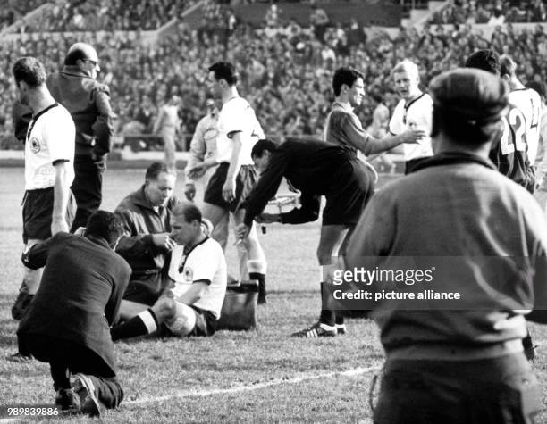 German midfielder Herbert Erhardt is sitting on the ground, injured, and is being treated. He is able to continue to play later on. Germany's...