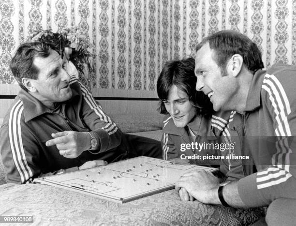 Swedish national football team coach Georg Ericsson is talking to his players Ralf Edstroem and Ove Grahn at the team hotel in Moenchengladbach....