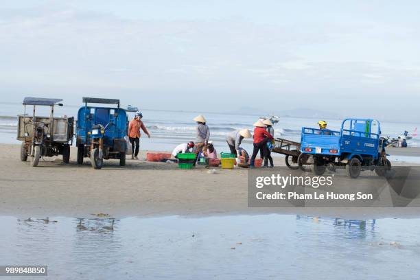 people trading fishes on the beach near long hai fish market - 網代船 ストックフォトと画像