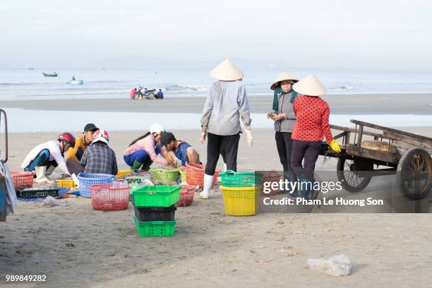 people trading fishes on the beach near long hai fish market - 網代船 ストックフォトと画像