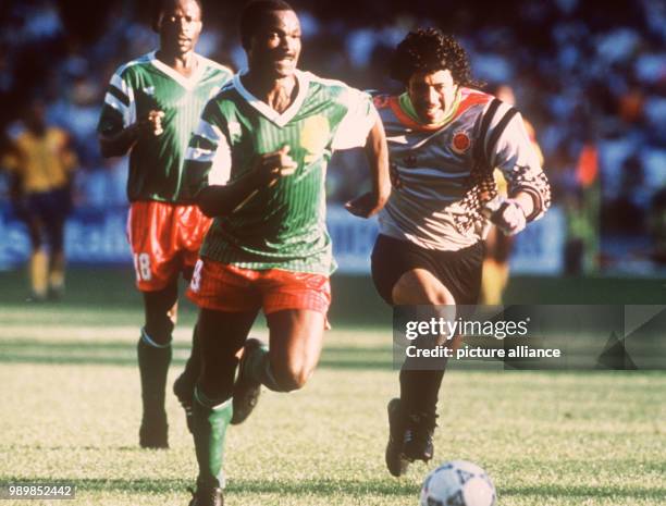 Cameroon's 38-year-old goalgetter Roger Milla takes away the ball from lightheaded Colombian goalkeeper Rene Higuita and wins the race. Mila scores...