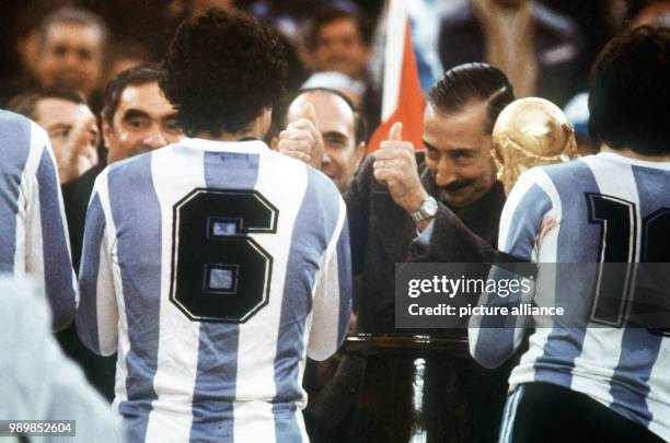 Chief of the Argentinian Junta, general Joreg Videla, is happy. He is presenting the World Cup trophy to Argentina's team captain Daniel Passarella,...