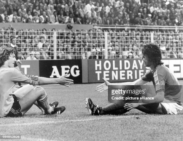 Dutch defender Ruud Krol and Swedish striker Ralf Edstroem are shaking hands after both players fell in a tackle. The 1974 FIFA World Cup match at...