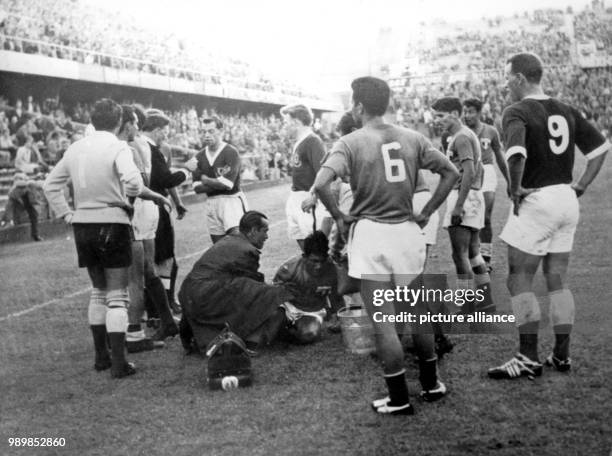 Injured Mexican striker Roca Garcia is sitting on the ground dazed and is been taken care of. Welsh centre forward John Charles is watching. The 1958...