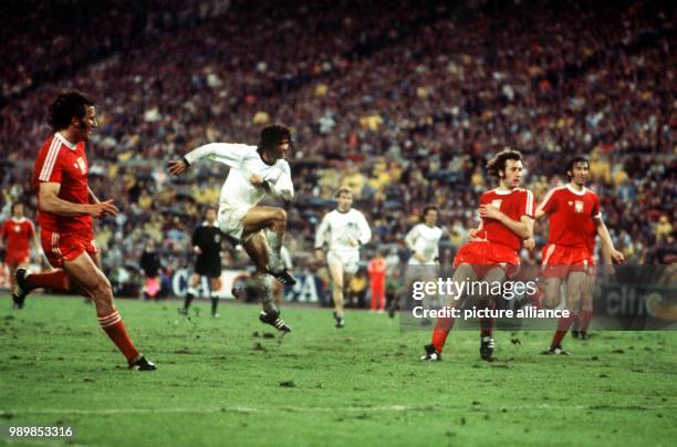 German goalgetter Gerd Mueller kicks and scores the winning goal. Polish opponents Adam Musial, Antoni Szymanowski and Kazimierz Deyna are without a...