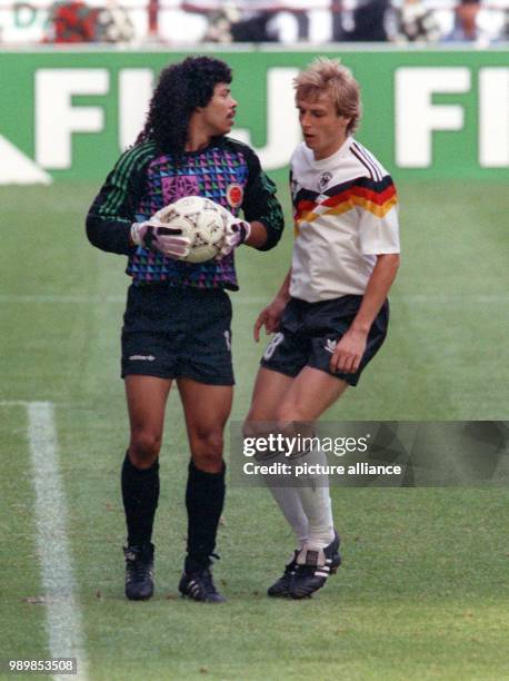 Spellbound German striker Juergen Klinsmann stares at the ball that is held provocatively long by Colombian's goalkeeper. The match ends with a 1:1...