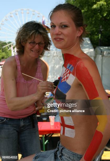 Flags of the participating nations of the World Cup are painted on the body of Larissa at the central fan area in Berlin at Tuesday, 13 June 2006. In...