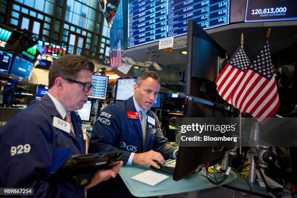 Traders work on the floor of the New York Stock Exchange in New York, U.S., on Monday, July 2, 2018. U.S. Stocks fell on lower than normal volume as...