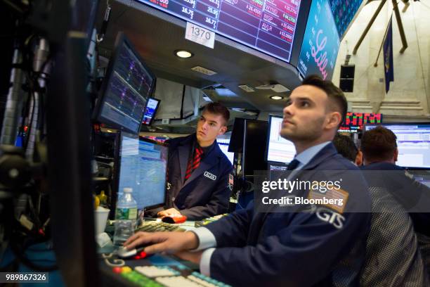 Traders work on the floor of the New York Stock Exchange in New York, U.S., on Monday, July 2, 2018. U.S. Stocks fell on lower than normal volume as...