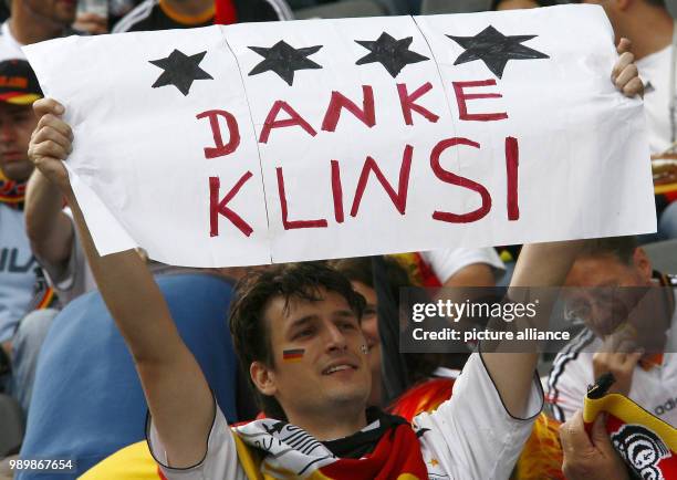 German supporter shows a placard with the inscription "Thanks Klinsi" to thank the German coach Juergen Klinsmann for the good performance of his...