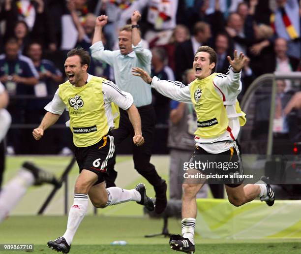 German team coach Juergen Klinsmann , Jens Nowotny and Miroslav Klose celebrate after the quarter final of the 2006 FIFA World Cup between Germany...