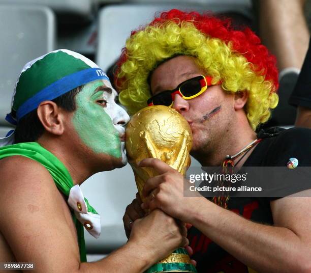 German and an italian supporter kiss a copy of the world cup prior to the semi final of the 2006 FIFA World Cup between Germany and Italy in...