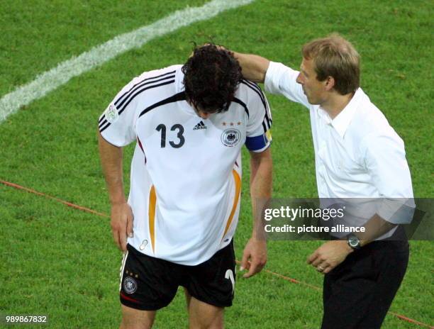 German coach Juergen Klinsmann talks to Michael Ballack after Germany looses 0-2 after extra time against Italy during the semi final of the 2006...