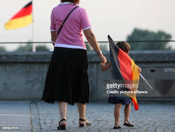 An der Hand seiner Mutter geht am Dienstagabend in Düsseldorf während des WM-Spiels Deutschland gegen Italien ein kleiner Junge mit einer...
