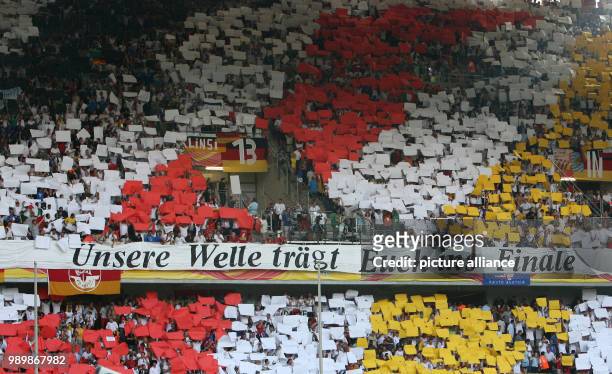 Deutsche Fans haben ein Spruchband mit der Aufschrift "Unsere Welle trägt Euch ins Finale" angebracht und halten untrerstützend farbige Schilder in...