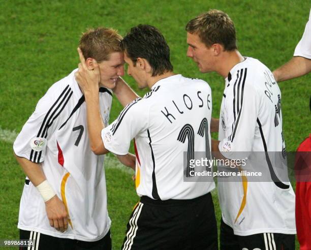 Bastian Schweinsteiger of Germany celebrates with teammates Miroslav Klose and Lukas Podolski after scoring the 1-0 lead during the 3rd place match...