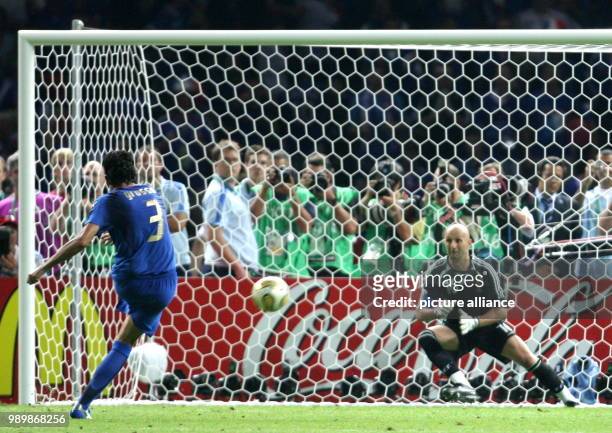 Italian Fabio Grosso scores the decisive 5-3 against French Fabien Barthez during penalty shoot out of the final of the 2006 FIFA World Cup between...