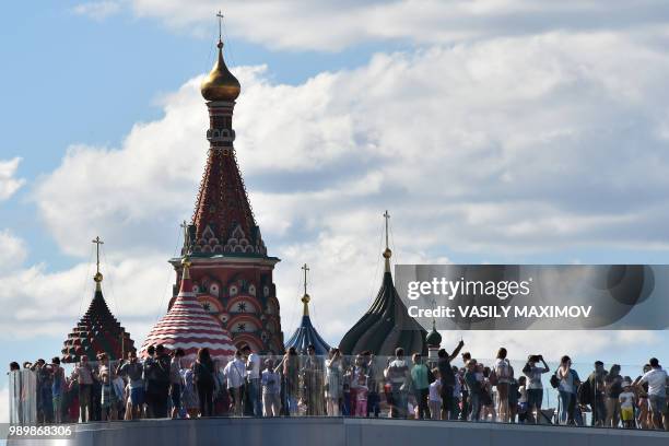 Tourists enjoy the view from an observation deck overlooking the Moscow River in front of the Kremlin in central Moscow on July 2, 2018.