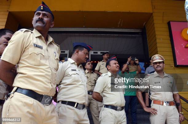 Policemen stand guard outside Balaji Multiplex Kopar Khairane in view of MNS protest against exorbitant prices of the food products served inside the...