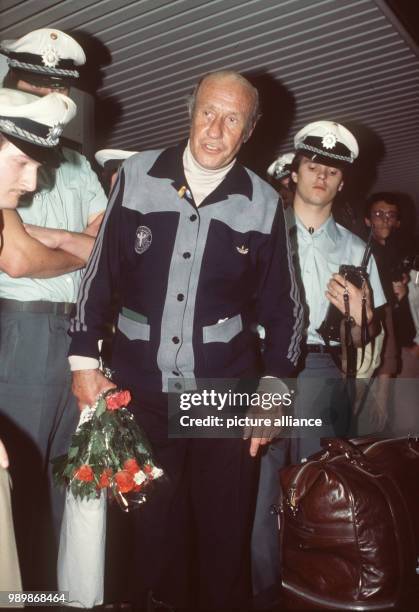 German team coach Helmut Schoen under police protection is arriving at Frankfurt Airport with the German team, after being knocked out by Austria in...