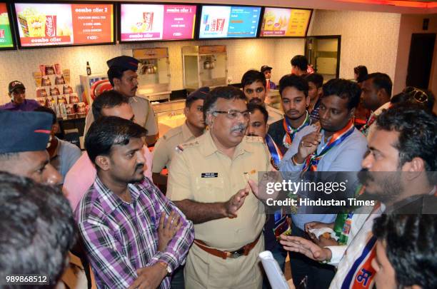 Policemen having talk with MNS workers at Balaji Multiplex Kopar Khairane during their protest against exorbitant prices of the food products served...