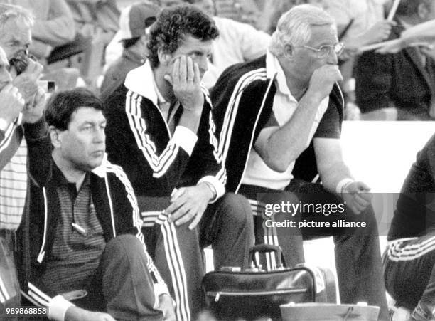 Jupp Derwall, assistant coach Erich Ribbeck and Horst Schmidt stony-faced on the coach's bench after Germany lost 1:4 to Brazil at the FIFA...
