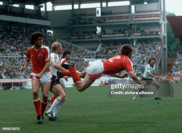 Fußball-WM 1982 in Gijon, Spanien: Deutschland-Oesterreich 1:0 Bernd KRAUSS "hebt ab", li. Bruno PEZZEY und Horst HRUBESCH . © Foto: Werek